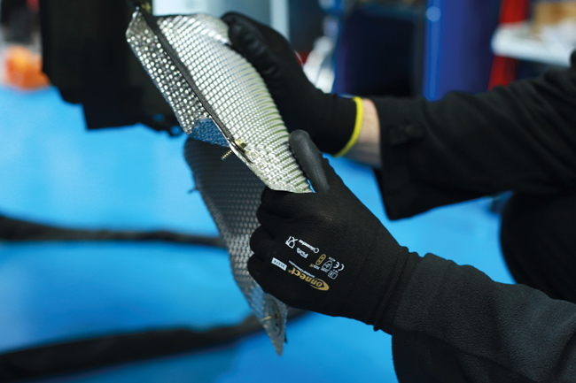 Handling exhaust heat shield wearing Mechanics Cut Resistant Gloves by Connect (P/N 35374)